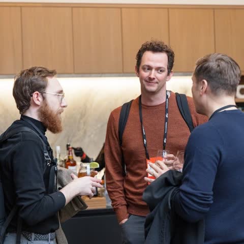 Kane in conversation with two attendees at a conference